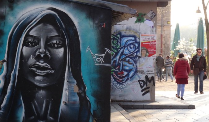 A large street art portrait painted on a wall in Paris, France