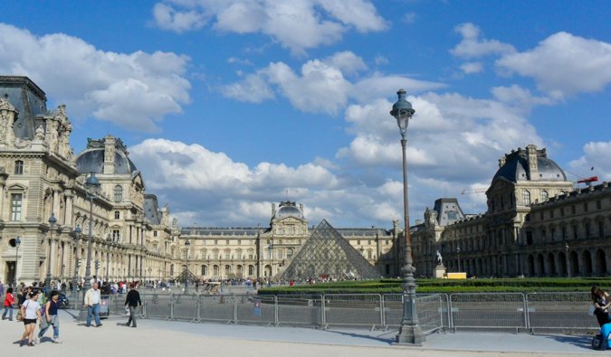 Tourists exploring the exterior of the Louvre in Paris, France
