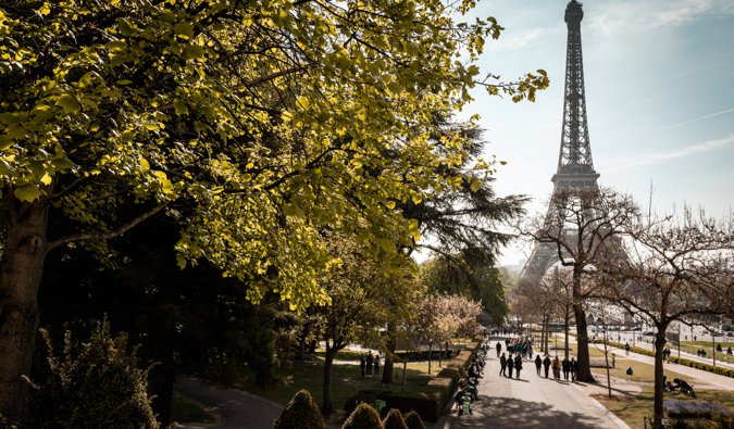 Walking down a path surrouned by trees near the Eiffel Tower in Paris, France