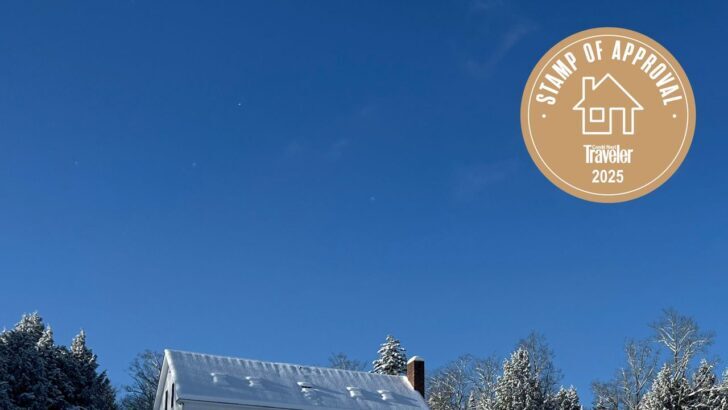 Casa de campo en Vermont cubierta de nieve con cielo azul despejado
