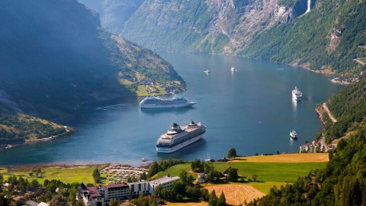 Tres cruceros navegando en un fiordo rodeado de montañas verdes