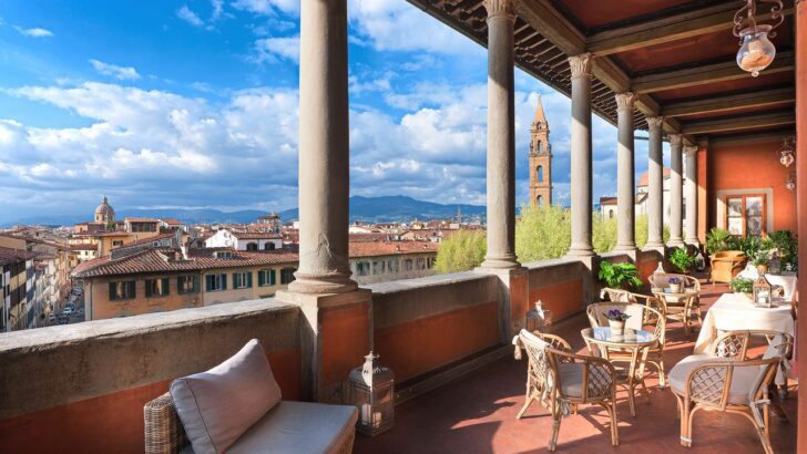 Vista desde la terraza de un hotel en Florencia con columnas y sillas.