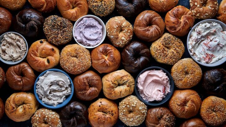 Variedad de bagels con diferentes cremas en tazones sobre fondo oscuro