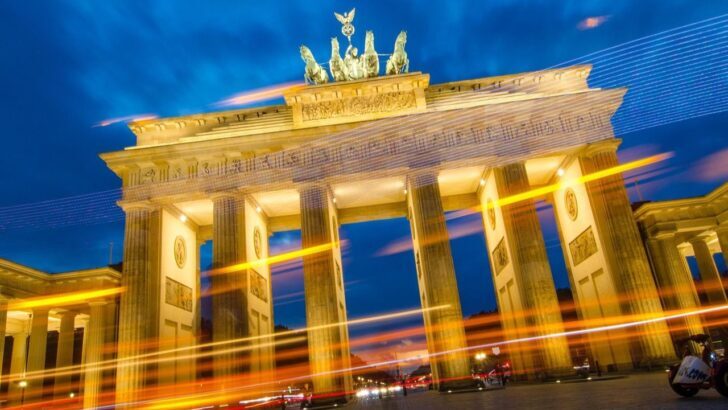 Puerta de Brandeburgo iluminada por la noche con luces en movimiento