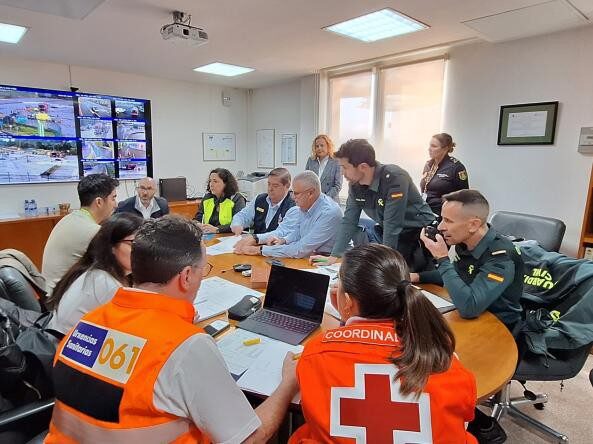 Equipo de emergencia coordinando simulacro en sala de control con pantallas