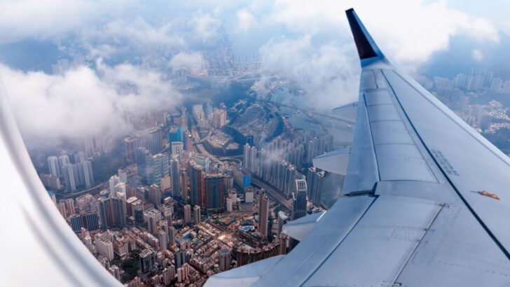 Vista aérea de una ciudad desde la ventana de un avión con nubes
