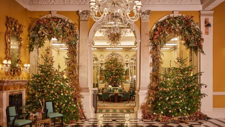 Vestíbulo de hotel en Londres decorado con árboles de Navidad y luces festivas