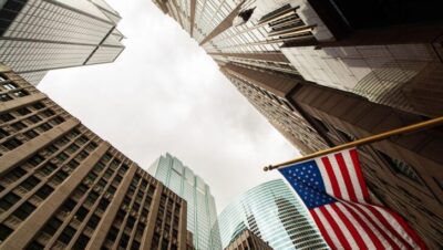 Vista ascendente de edificios altos con una bandera de EE. UU.