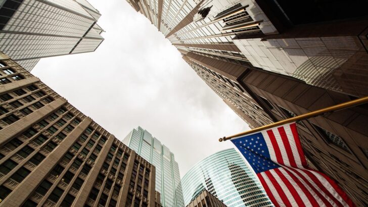 Vista ascendente de edificios altos con una bandera de EE. UU.