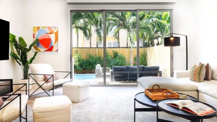 Sala de estar moderna con vista a la piscina y palmeras en Miami