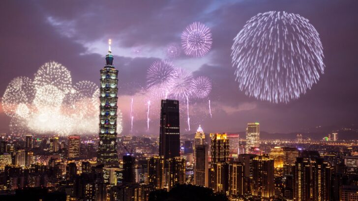 Fuegos artificiales iluminan el cielo sobre una ciudad durante la noche de Año Nuevo