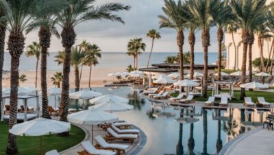 Vista de un lujoso resort en Los Cabos con piscina y palmeras frente al mar