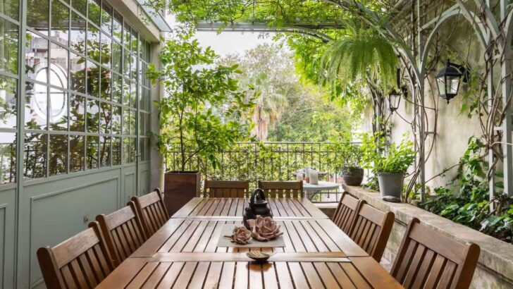 Terraza con mesa de madera rodeada de plantas verdes en Buenos Aires