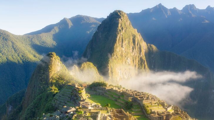 Vista matutina de Machu Picchu con niebla y montañas al fondo
